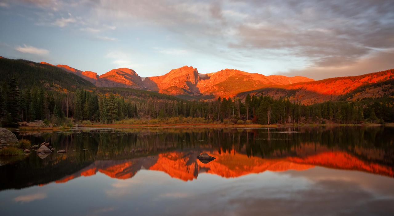 a picture of the sun sun setting behind mountains